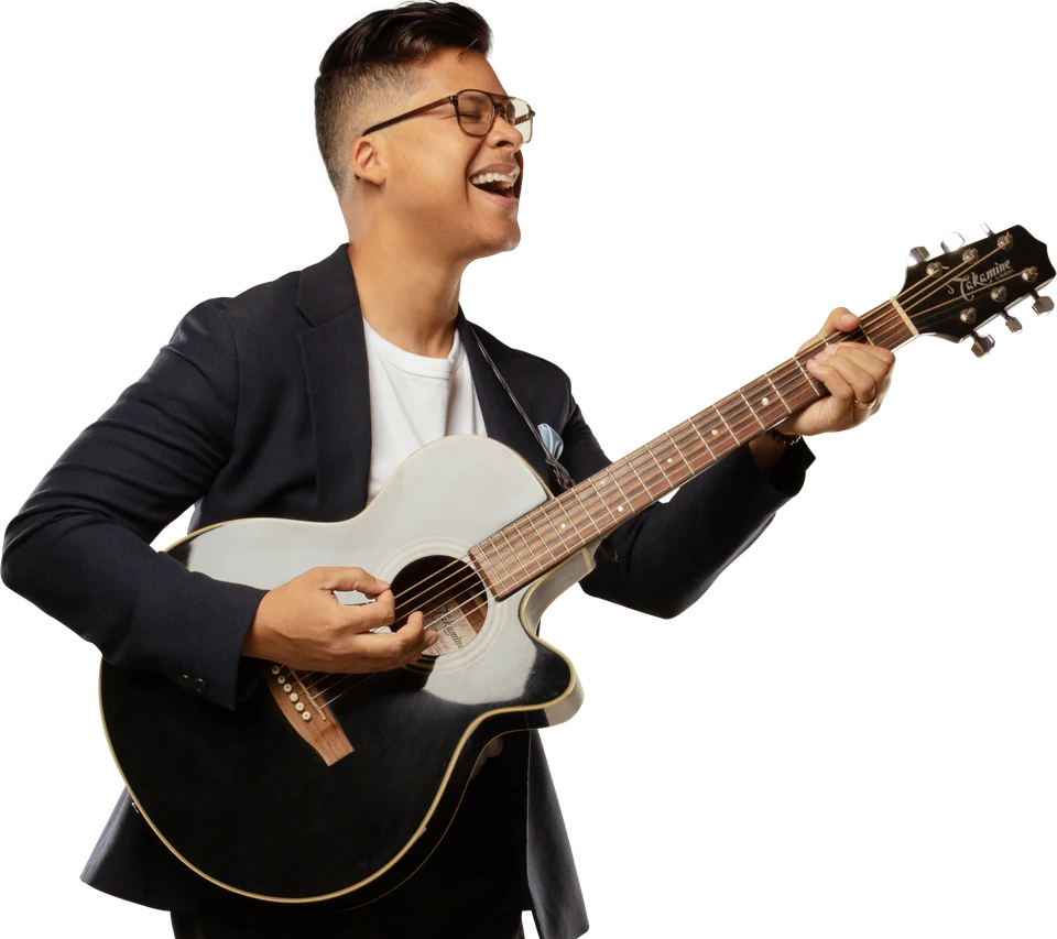 Jorge Luis del Hierro, Latin artist and CorPay USA ambassador, plays an acoustic guitar
